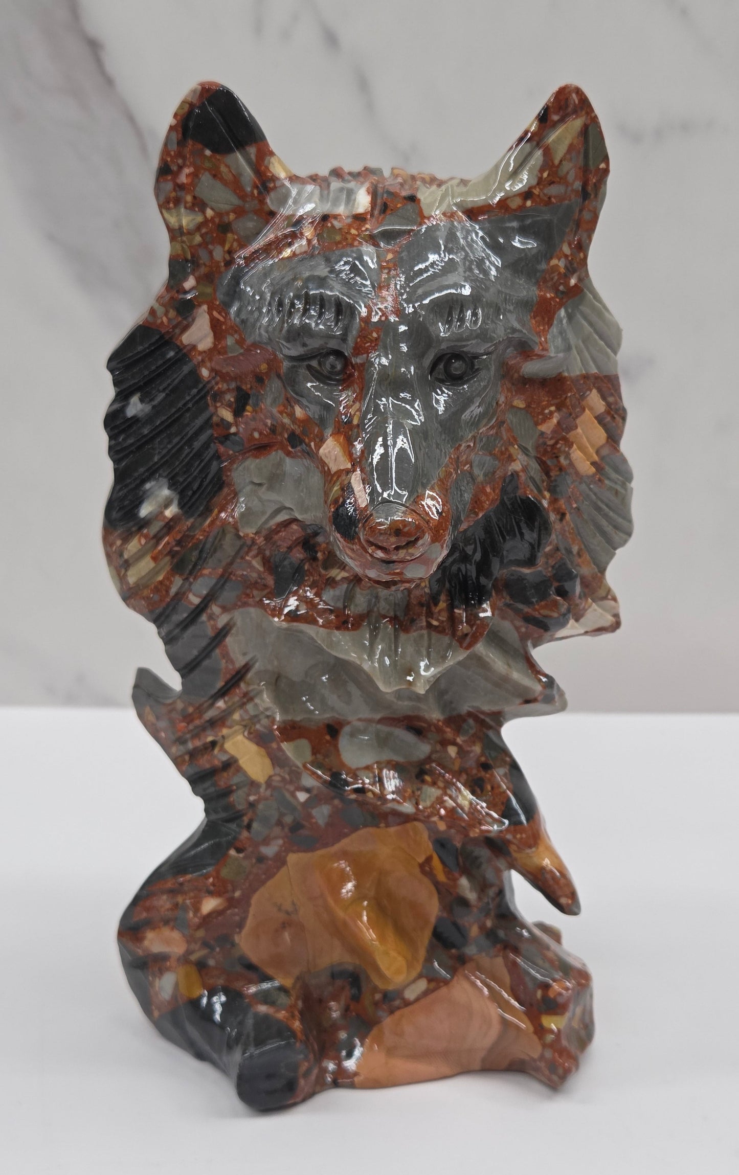 Wolf carving with a mix of brown, gray, and black colors on a white background
