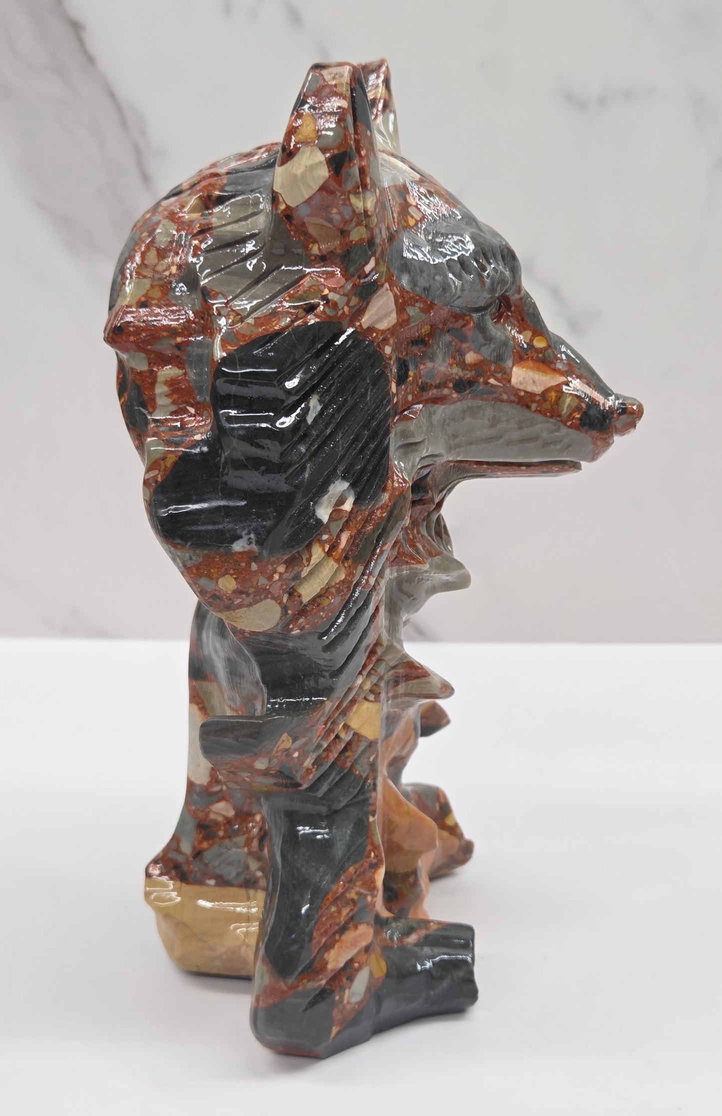 Wolf carving with a mix of brown, gray, and black colors on a white background
