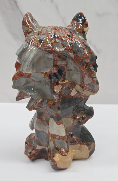 Wolf carving with a mix of brown, gray, and black colors on a white background