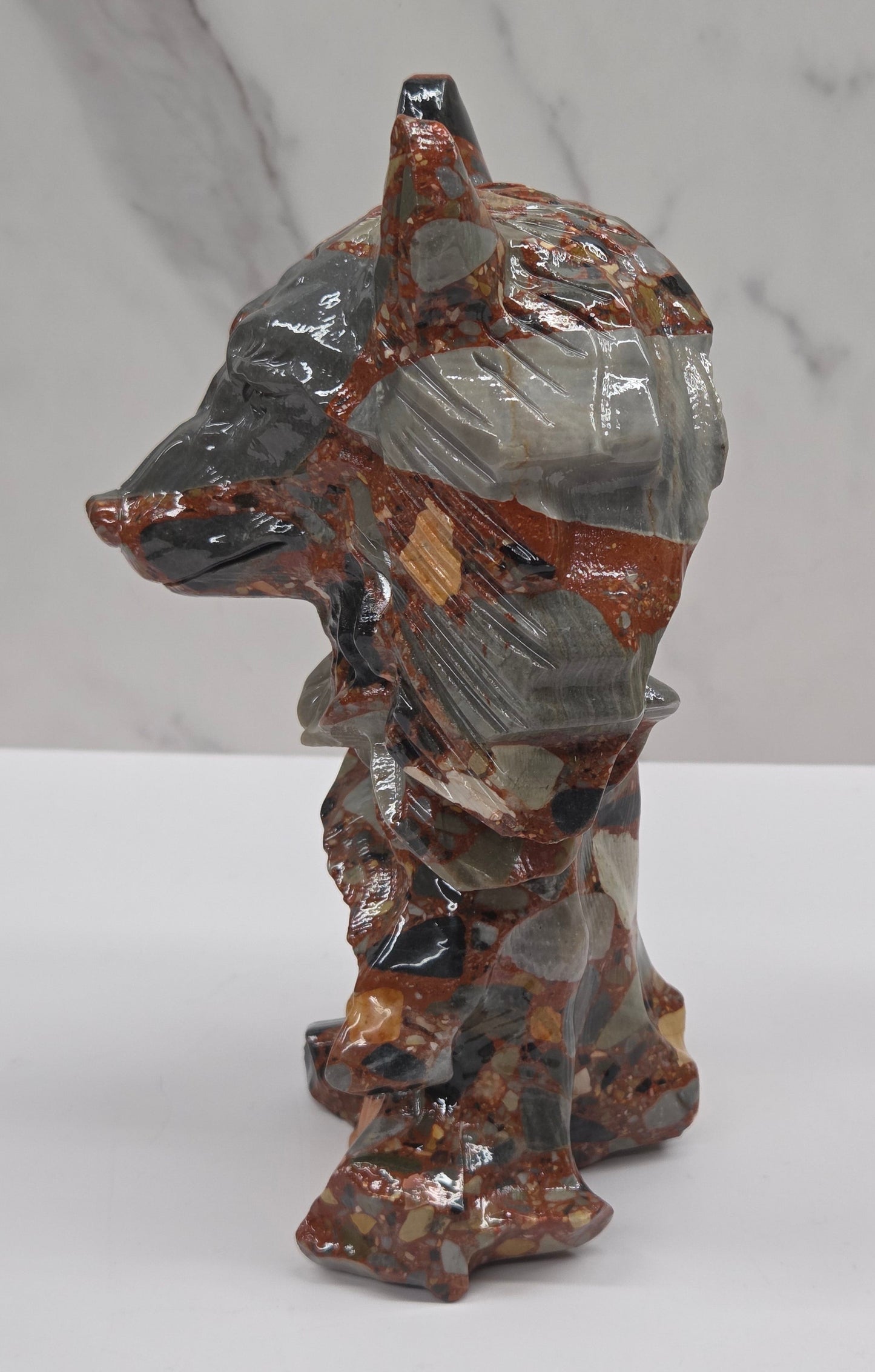 Wolf carving with a mix of brown, gray, and black colors on a white background