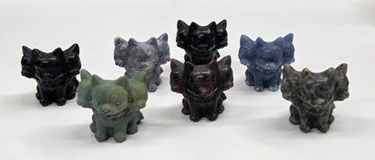 Set of six small crystal mythological cerberus animal figurines on a white surface