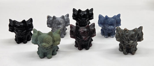 Set of six small crystal mythological cerberus animal figurines on a white surface