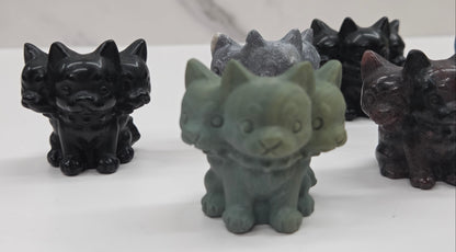 Set of small crystal mythological cerberus animal figurines on a white surface