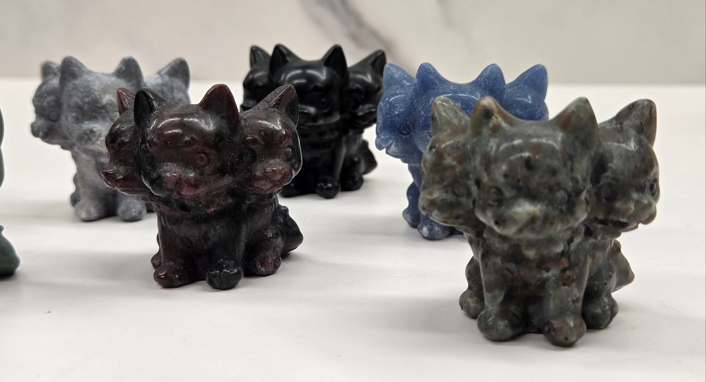 Set of small crystal mythological cerberus animal figurines on a white surface