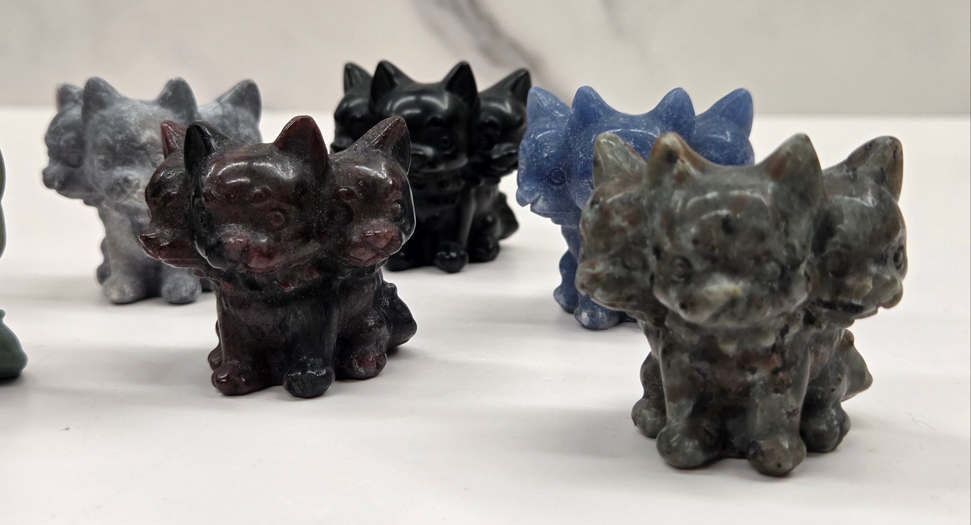 Set of small crystal mythological cerberus animal figurines on a white surface