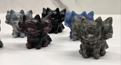 Set of small crystal mythological cerberus animal figurines on a white surface