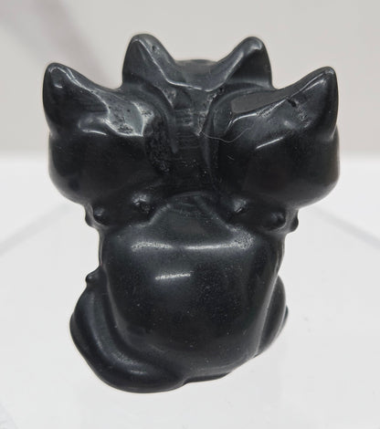 Obsidian small crystal mythological cerberus animal figurines on a white surface