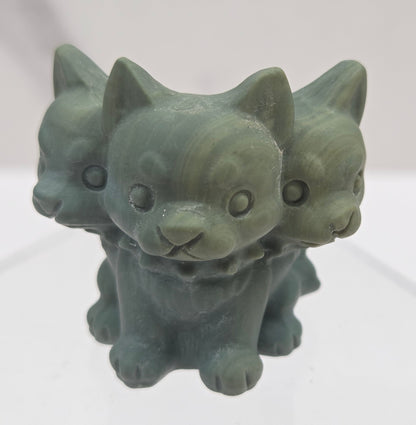 Green Jasper small crystal mythological cerberus animal figurines on a white surface