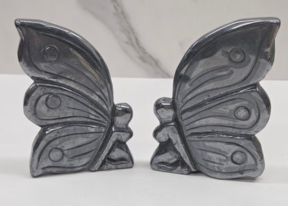 Silver hematite fairy carvings on a white background
