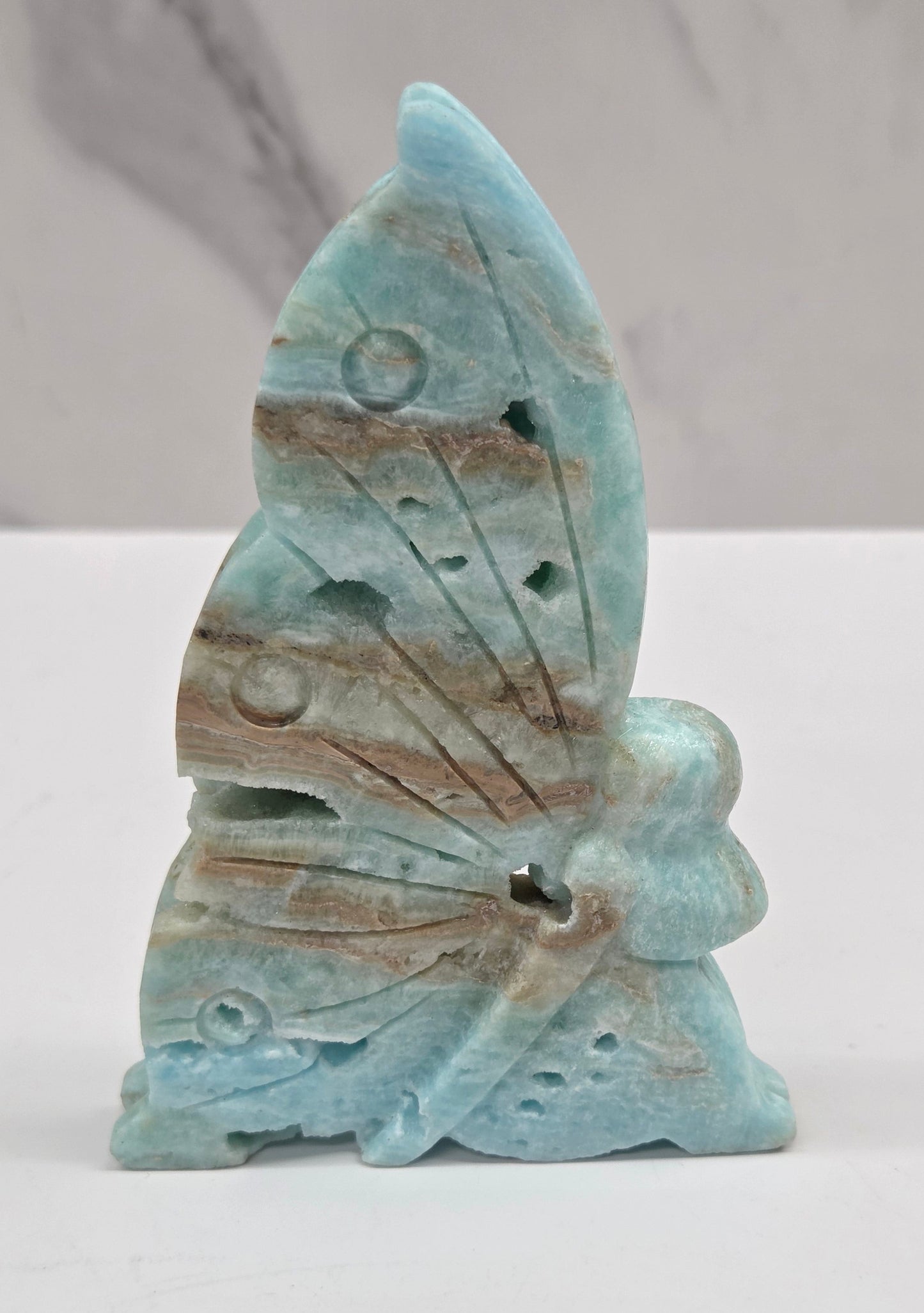 Blue Hemimorphite fairy carvings on a white background