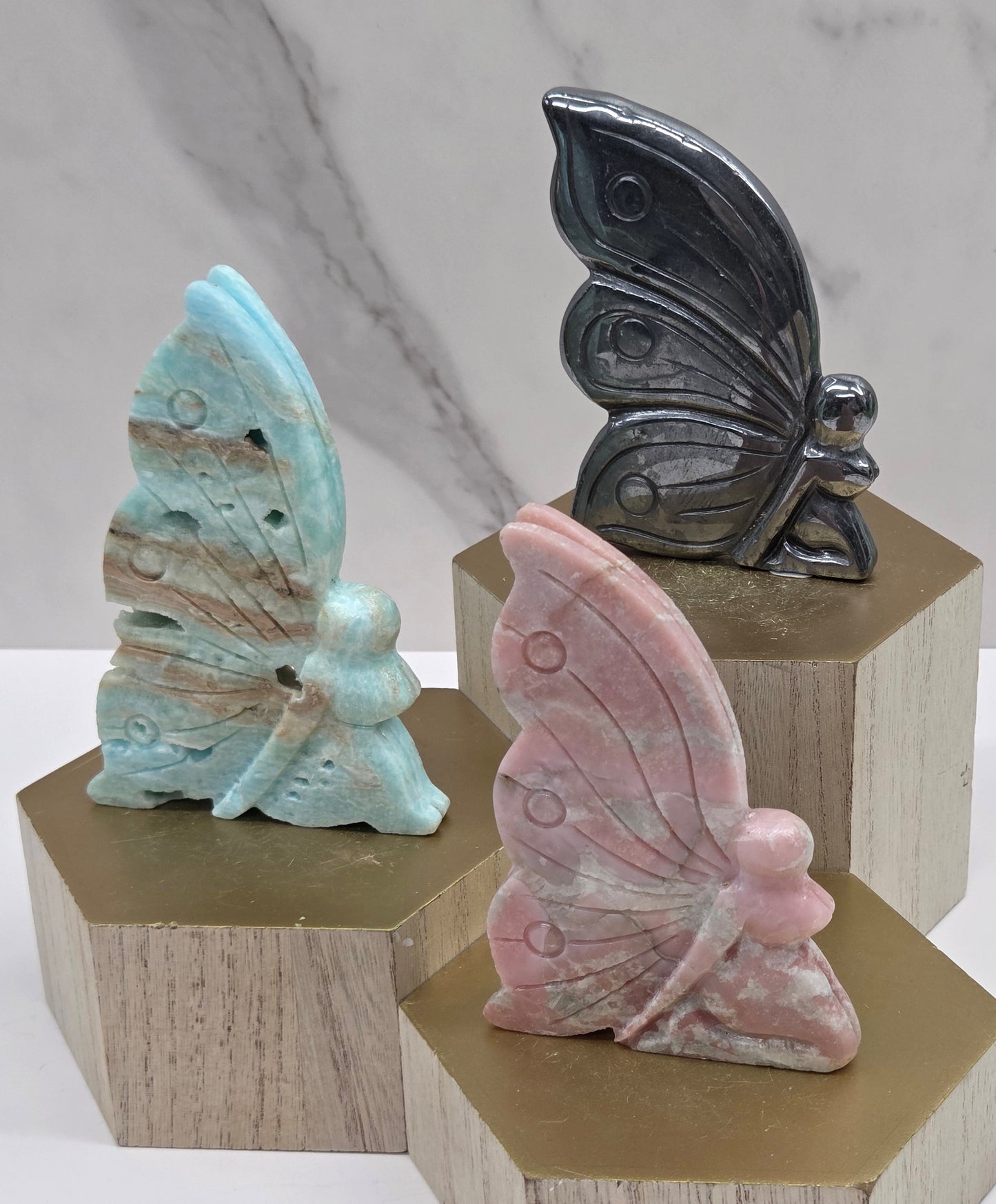 Fairy carvings in a variety of materials and colors on a wood block and white background