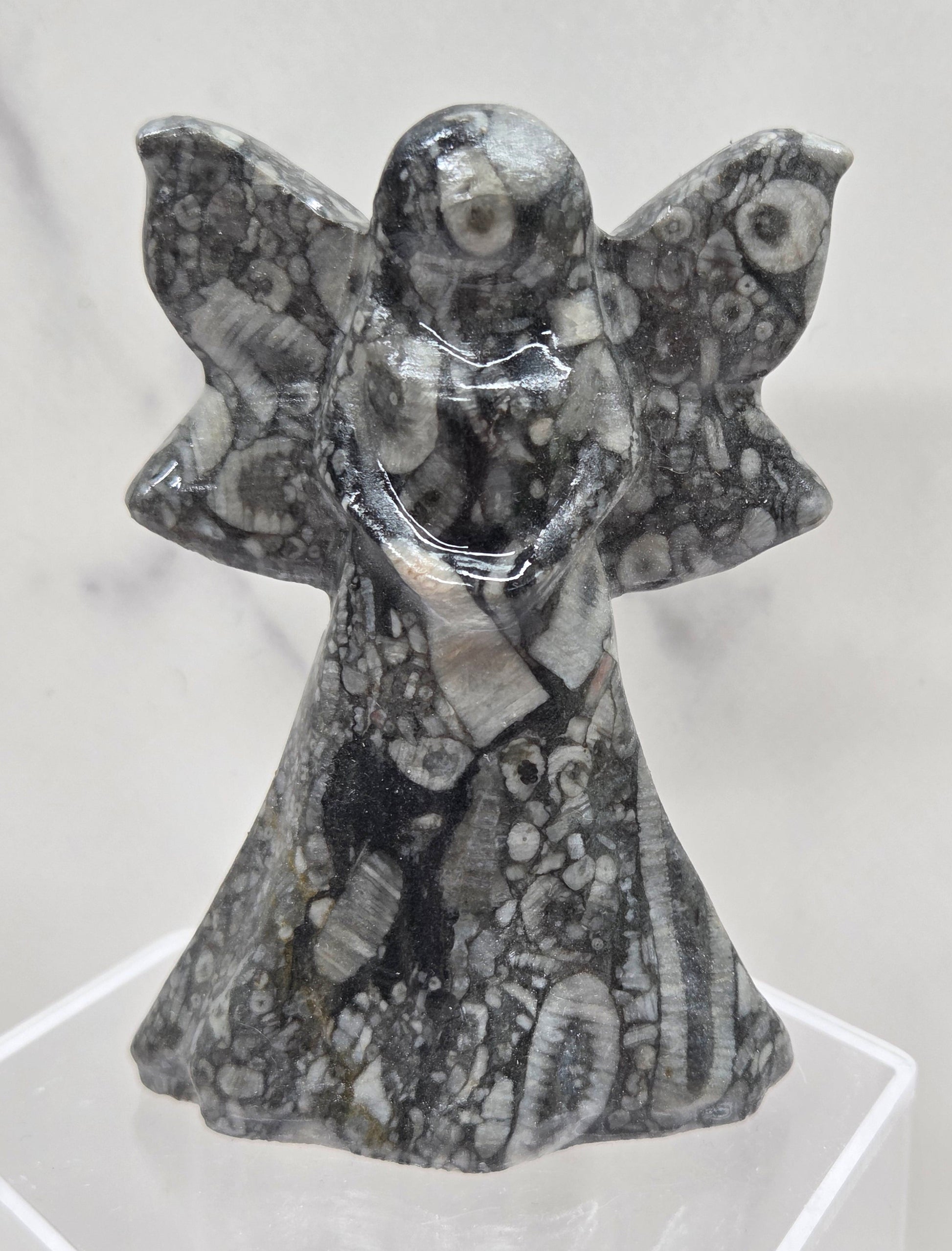 Crinoid fossil fairy figurine with visible fossils on a white background