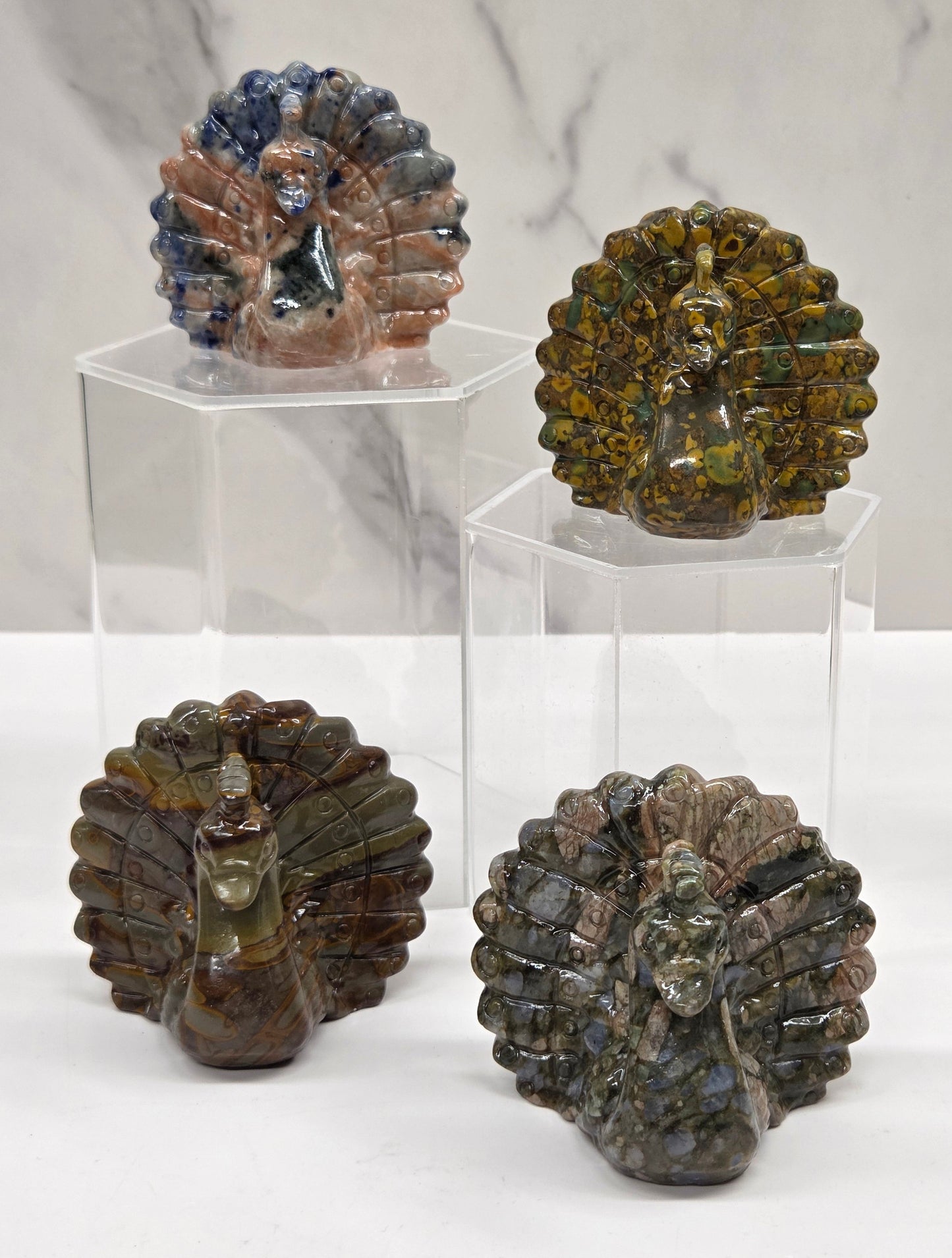 Peacock carvings in a variety of colors on a white background