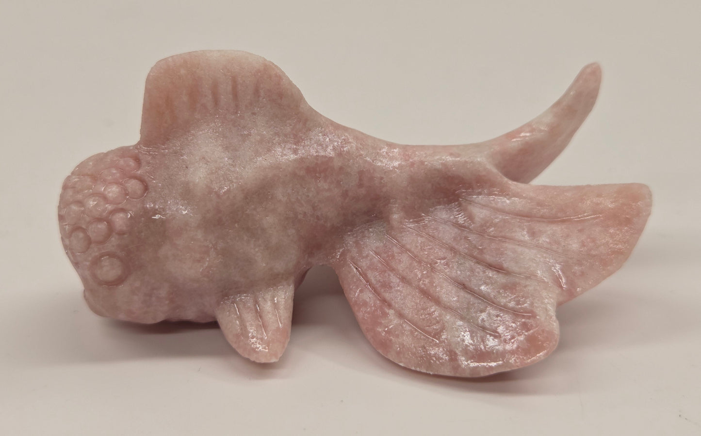 Pink Opal fish figurine on a white background