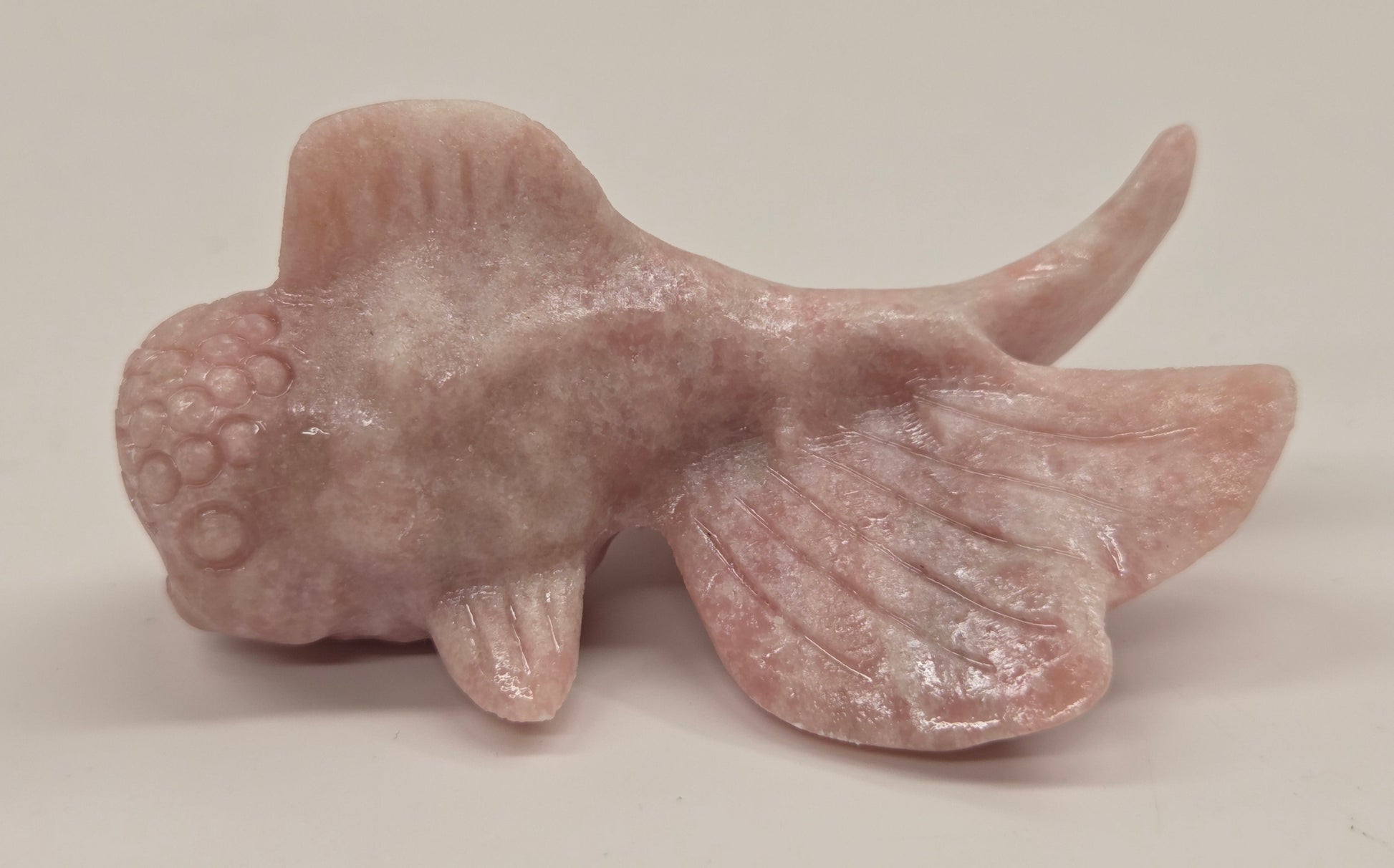 Pink Opal fish figurine on a white background