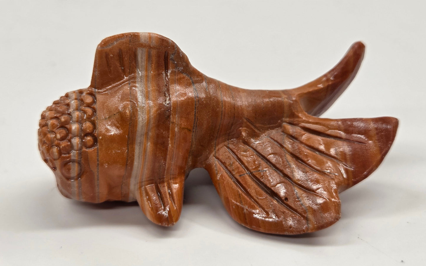 Red jasper fish figurine on a white background