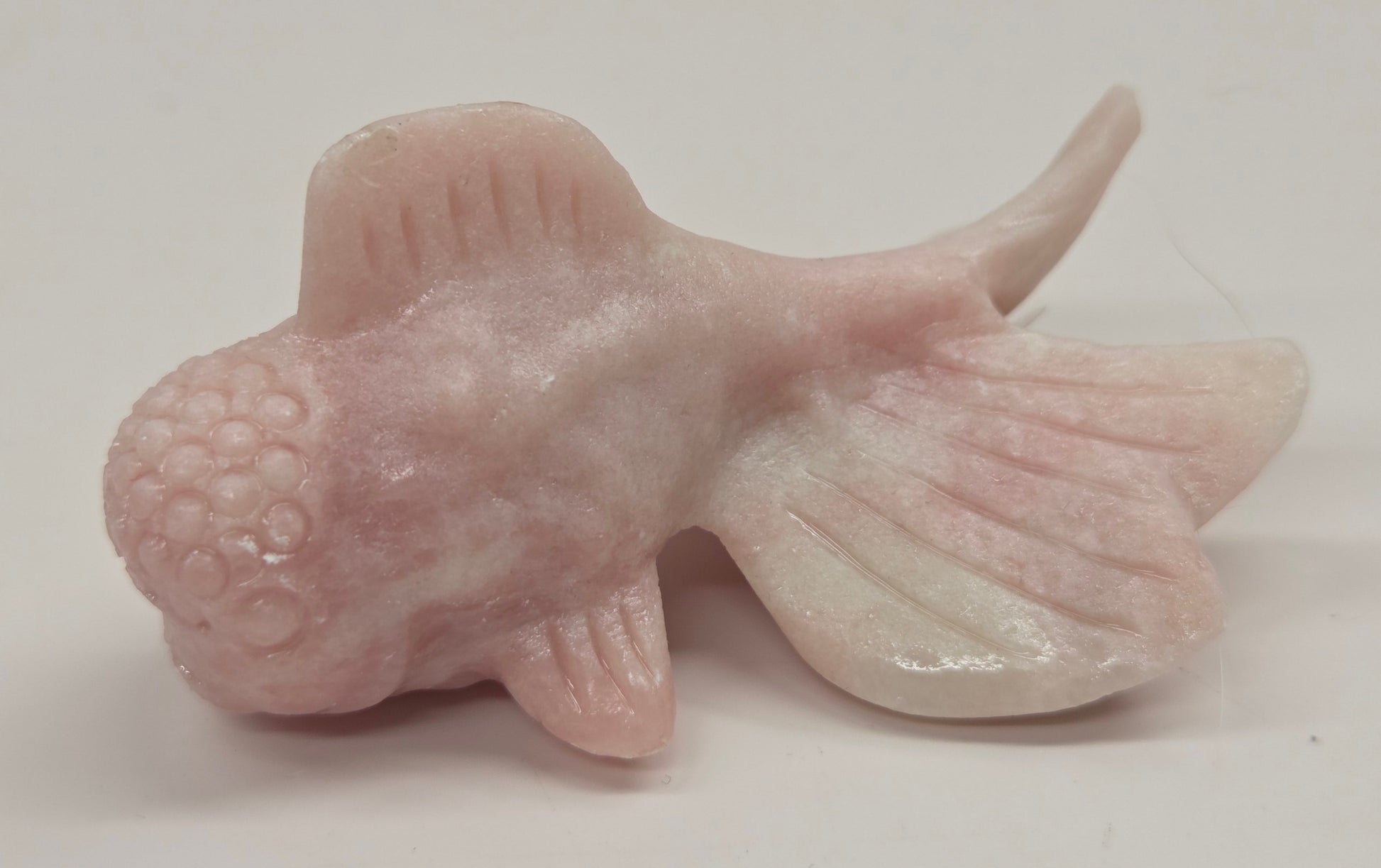 Pink Opal fish figurine on a white background