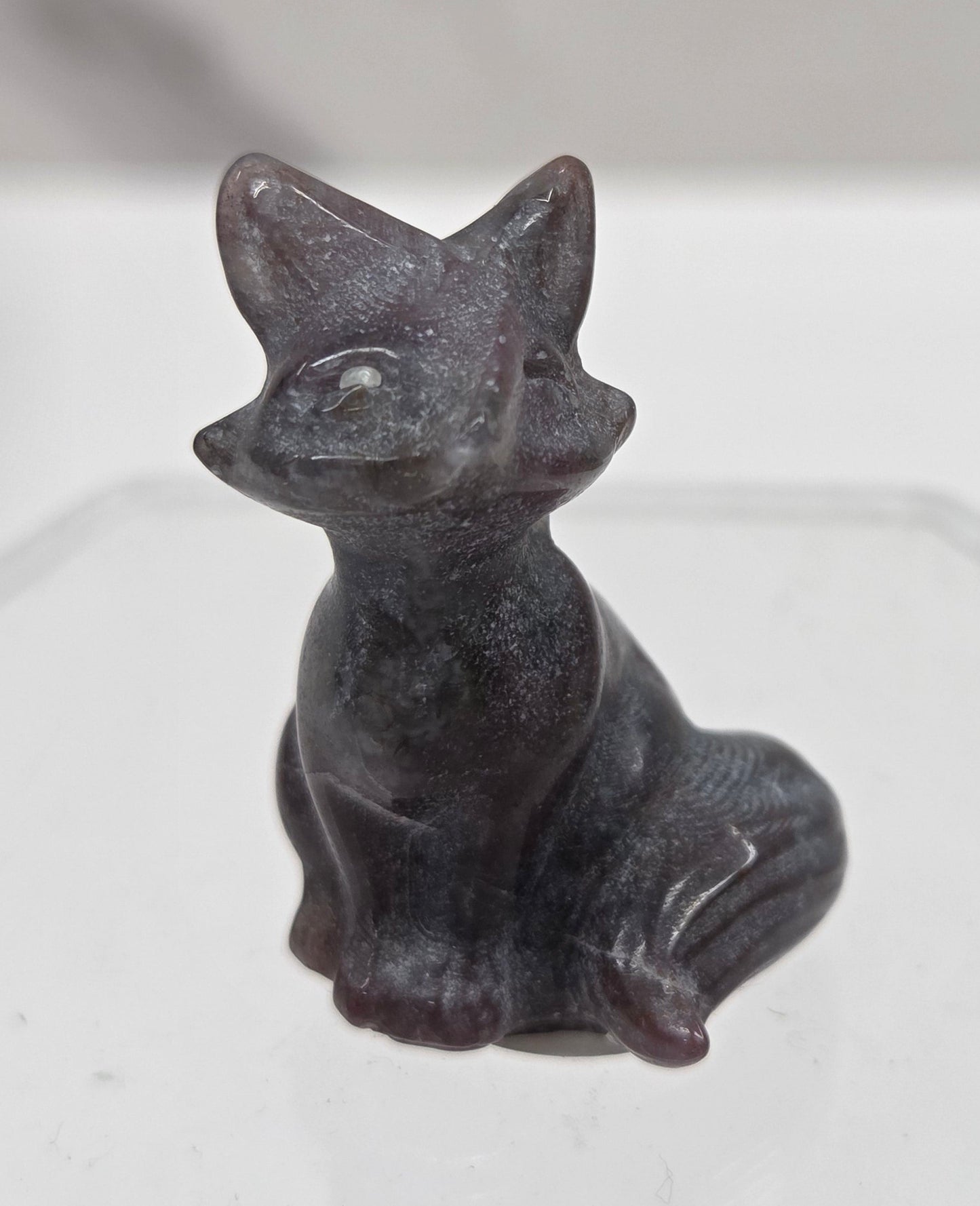 Small dark-colored fox carving on a  white background