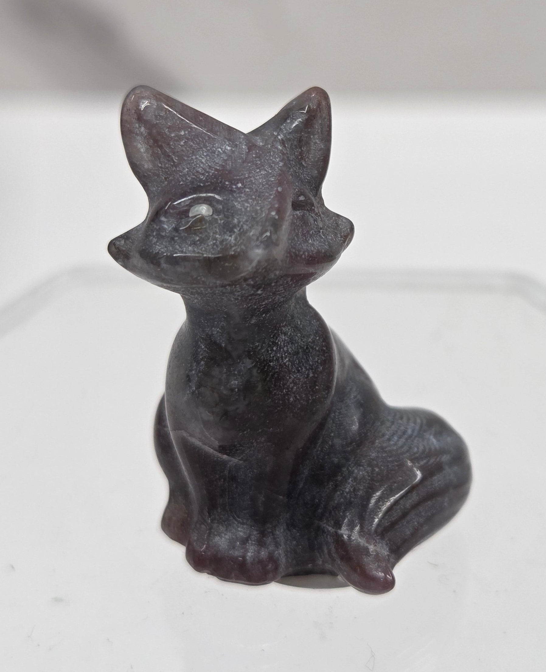 Small dark-colored fox carving on a  white background
