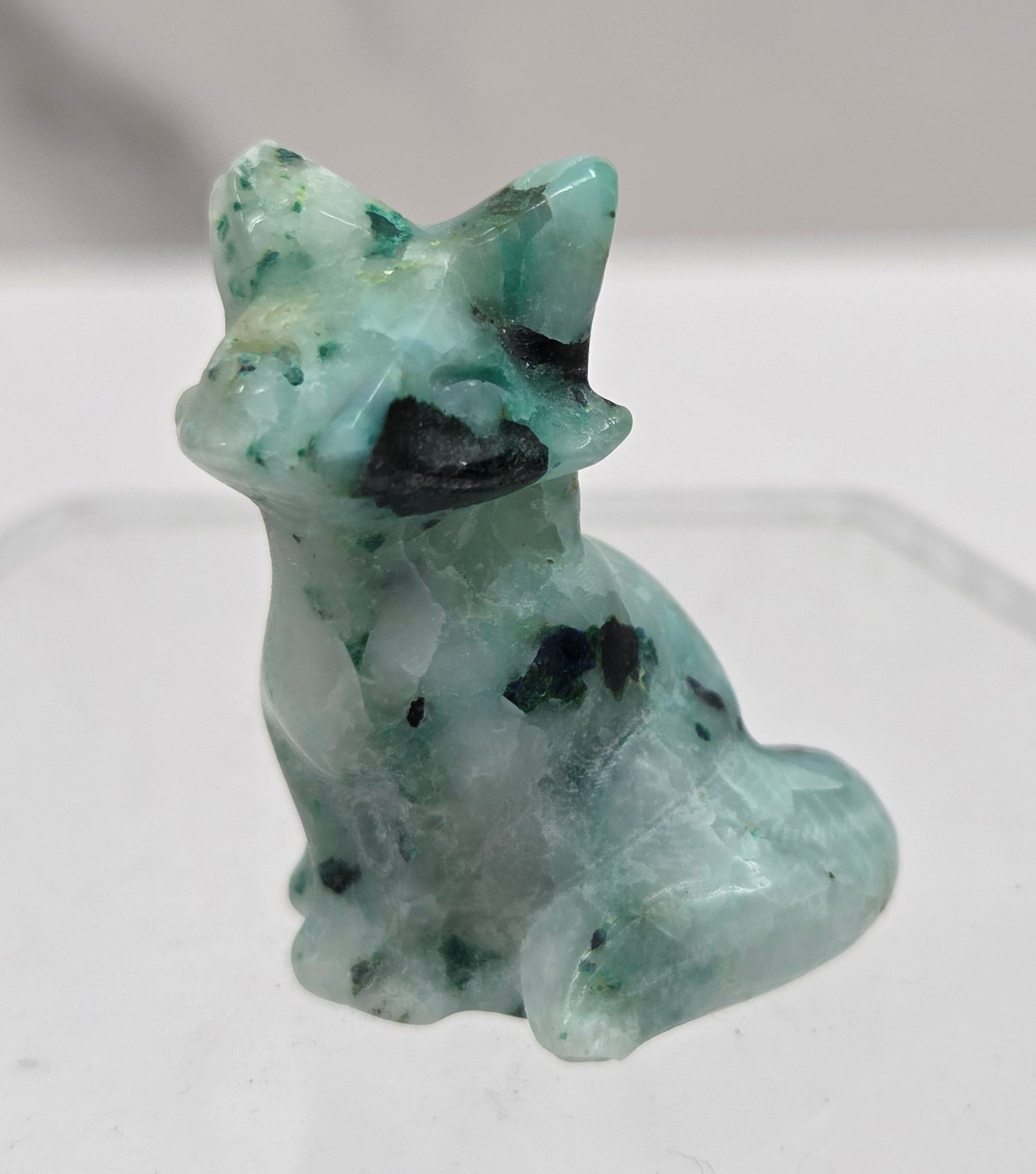 Small white and greenish-blue fox carving on a  white background