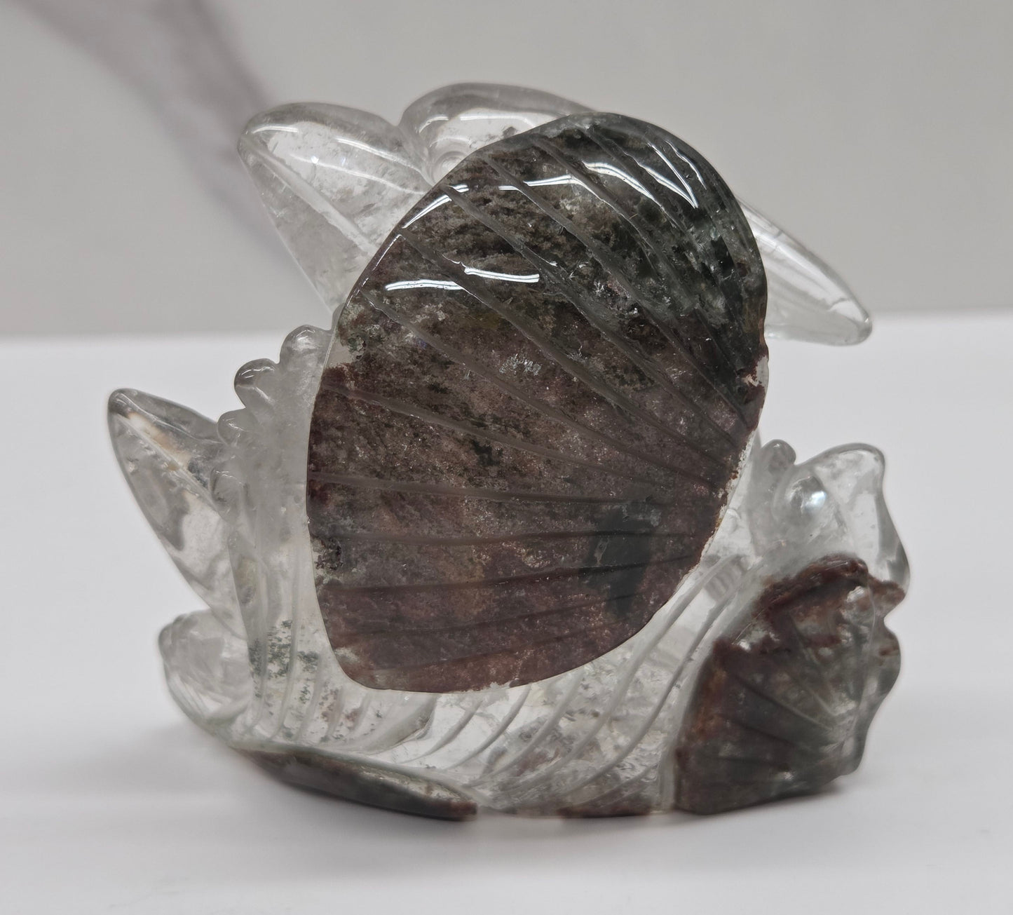 Dolphin in a wave shaped garden quartz crystal carving on a white background