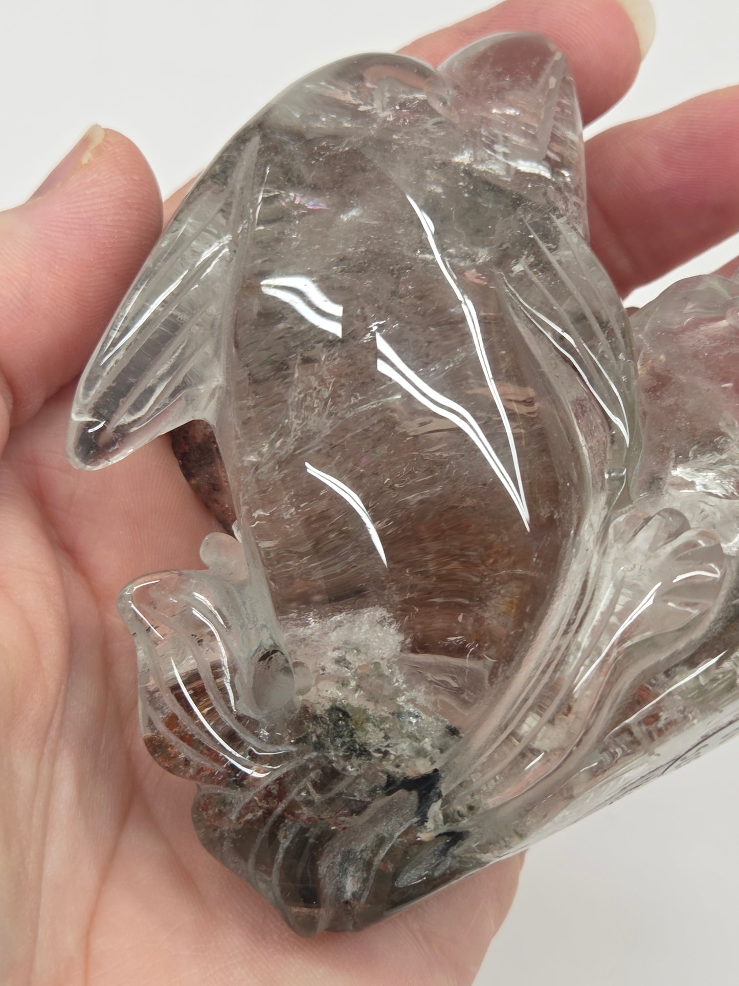 Dolphin in a wave shaped garden quartz crystal carving on a white background