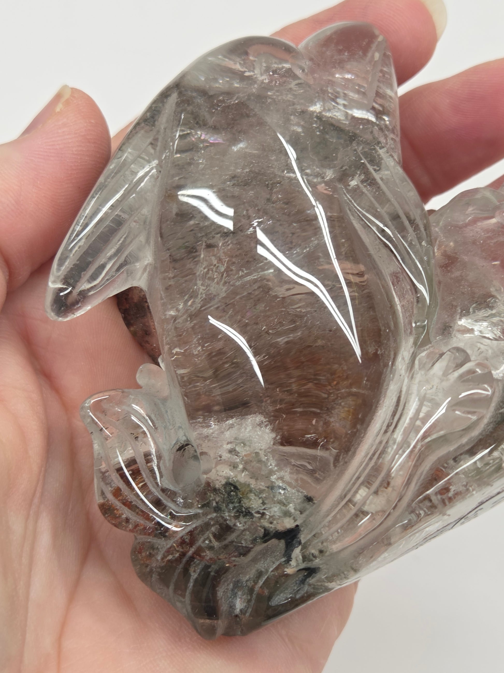 Dolphin in a wave shaped garden quartz crystal carving on a white background