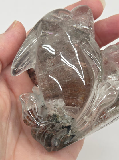 Dolphin in a wave shaped garden quartz crystal carving on a white background