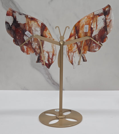 Fire Quartz butterfly wing carvings on a gold metal stand on a white background