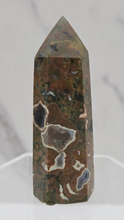 Decorative rainforest jasper tower with multiple colors and patterns on a white background