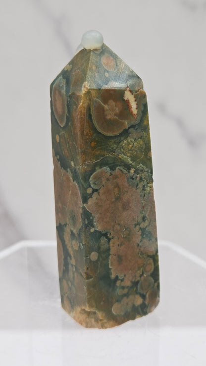 Decorative rainforest jasper tower with multiple colors and patterns on a white background