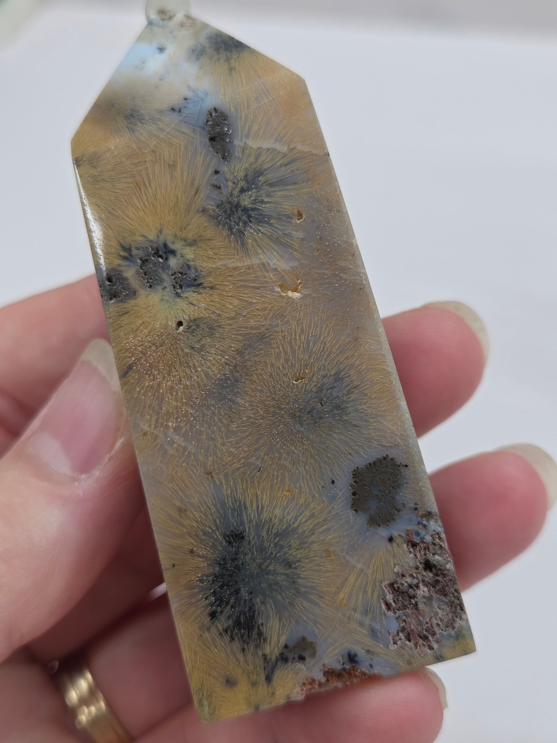 Close-up of a crystal point with inclusions against a white background