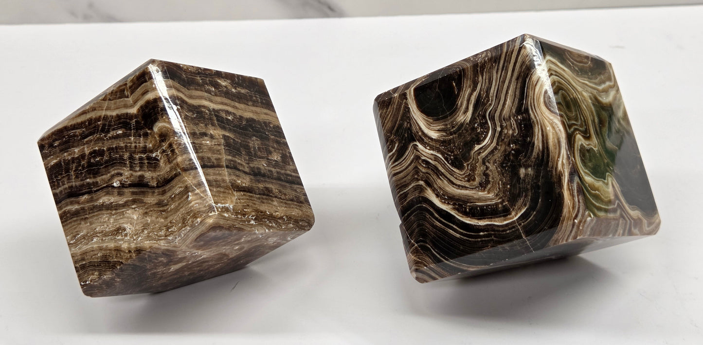 Two marbled chocolate calcite cubes on a white background