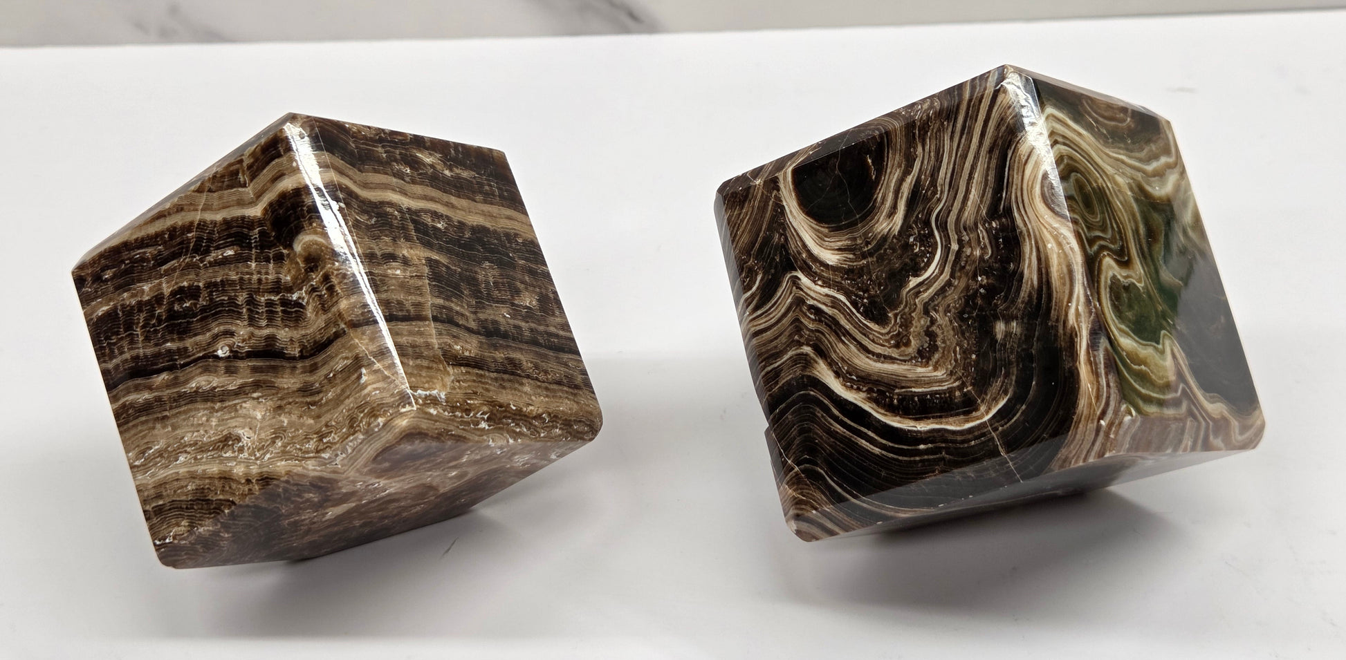 Two marbled chocolate calcite cubes on a white background