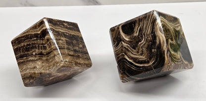 Two marbled chocolate calcite cubes on a white background