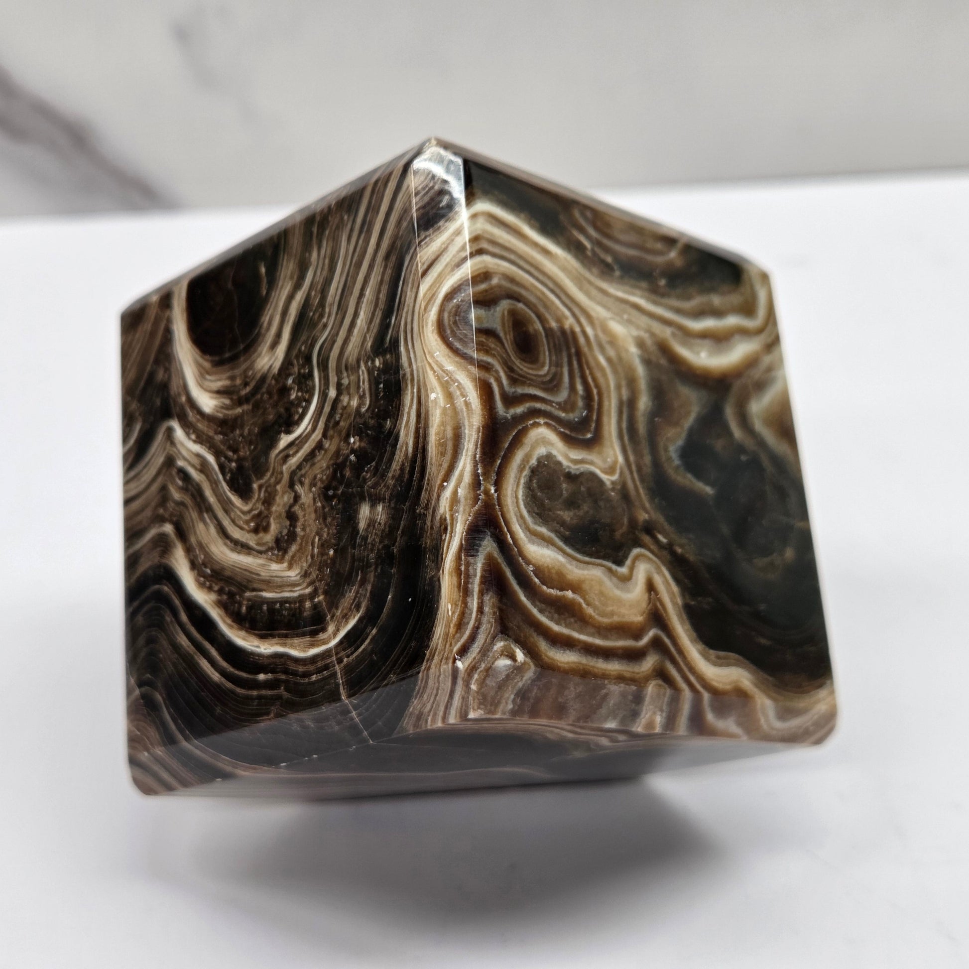 Marbled chocolate calcite cube on a white background