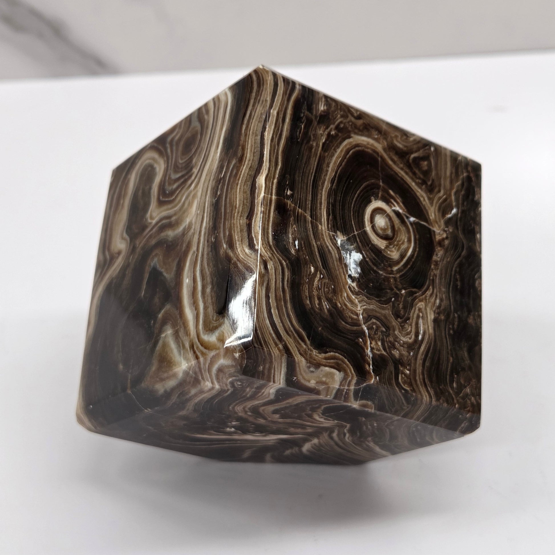 Marbled chocolate calcite cube on a white background