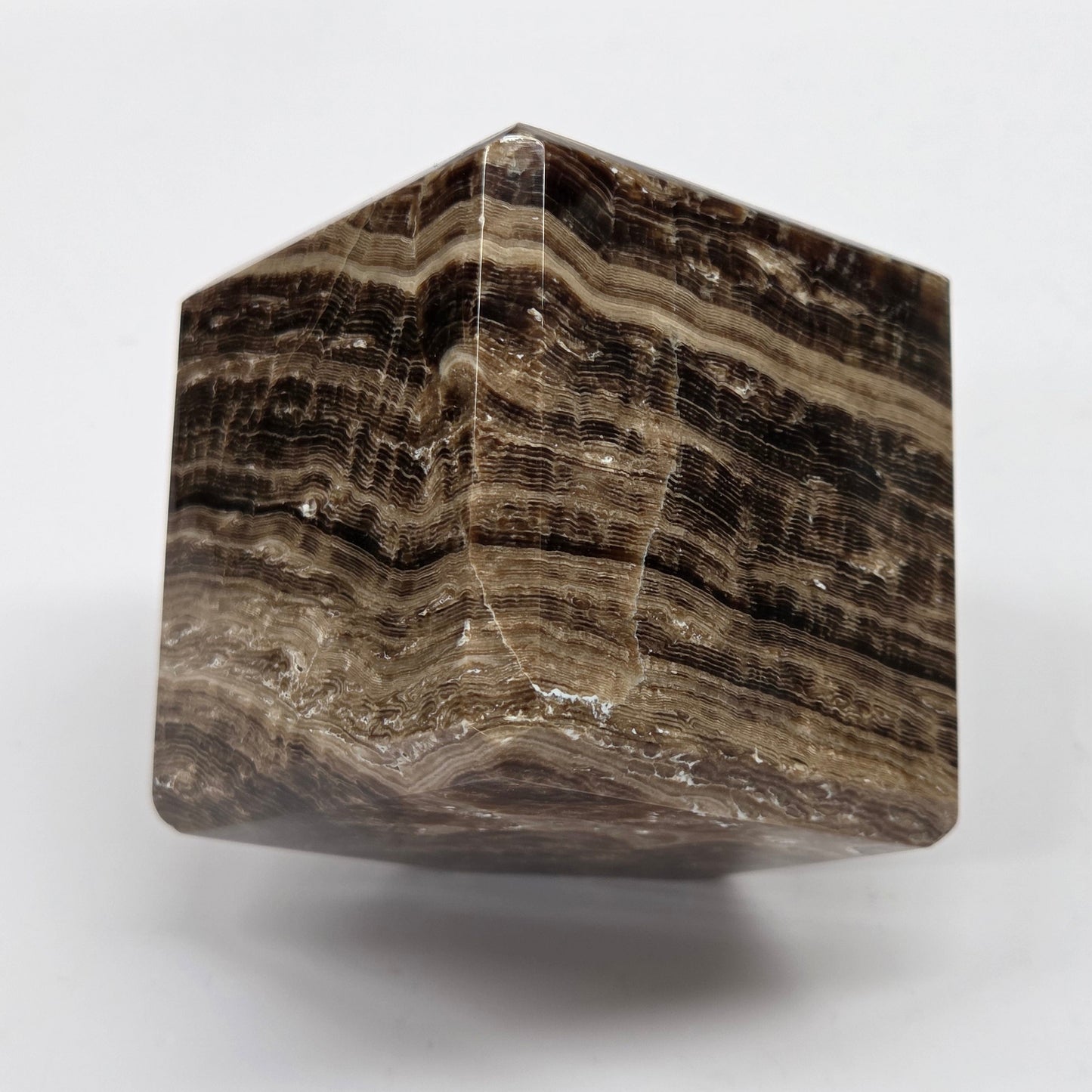 Marbled chocolate calcite cube on a white background