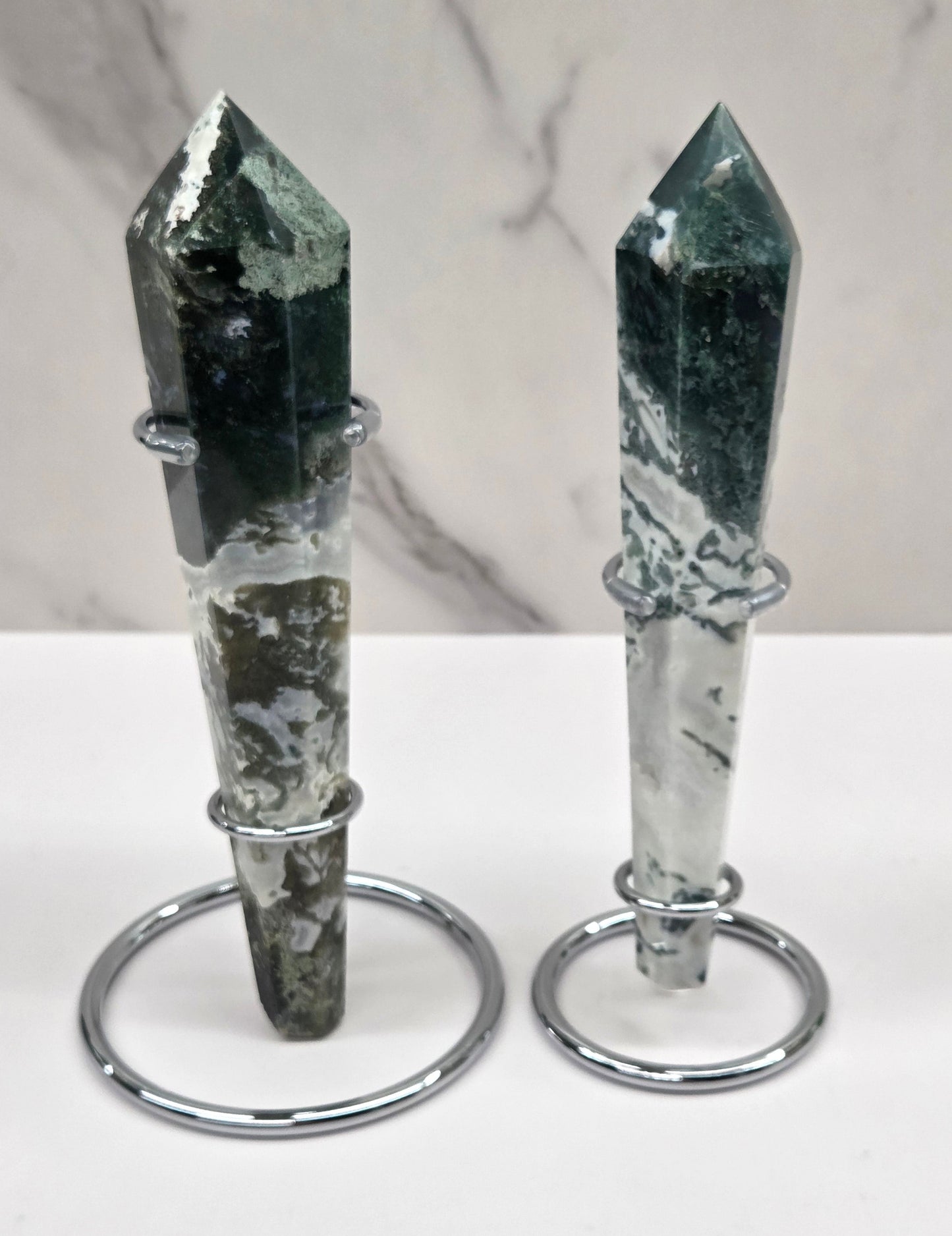 Set of Moss agate wand carvings in silver stands against a white background