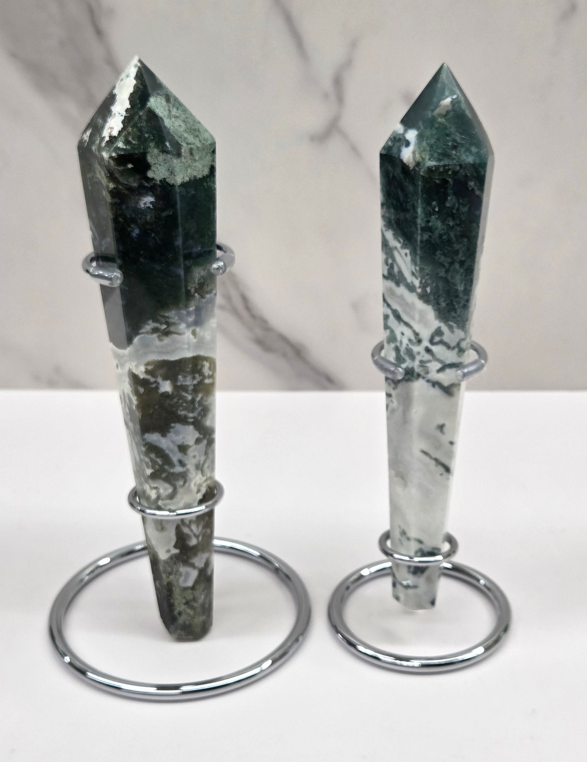 Set of Moss agate wand carvings in silver stands against a white background