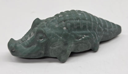 Carved green jasper crocodile on a white background