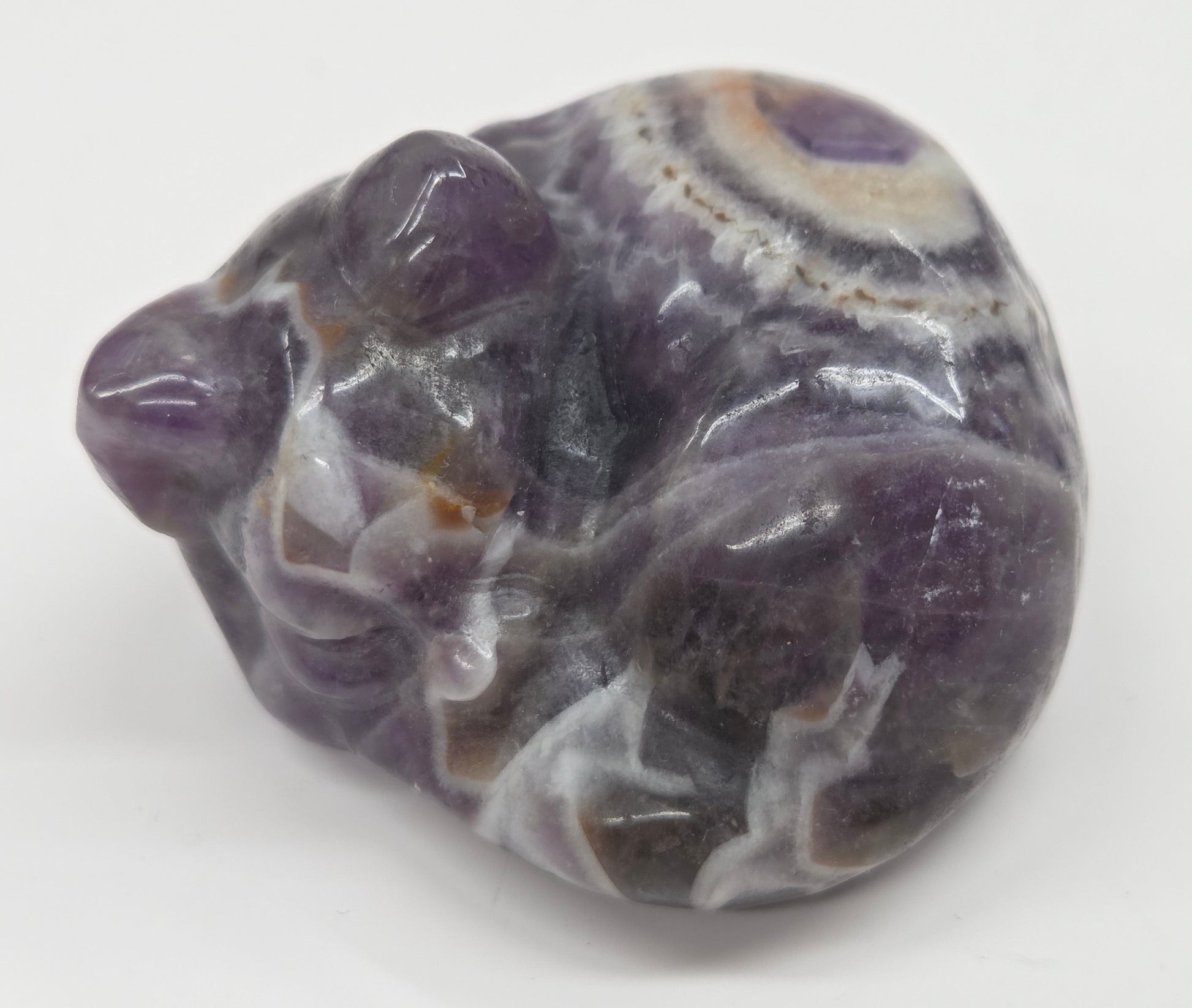 Dream Amethyst sleeping cat carving  with banding on a white background