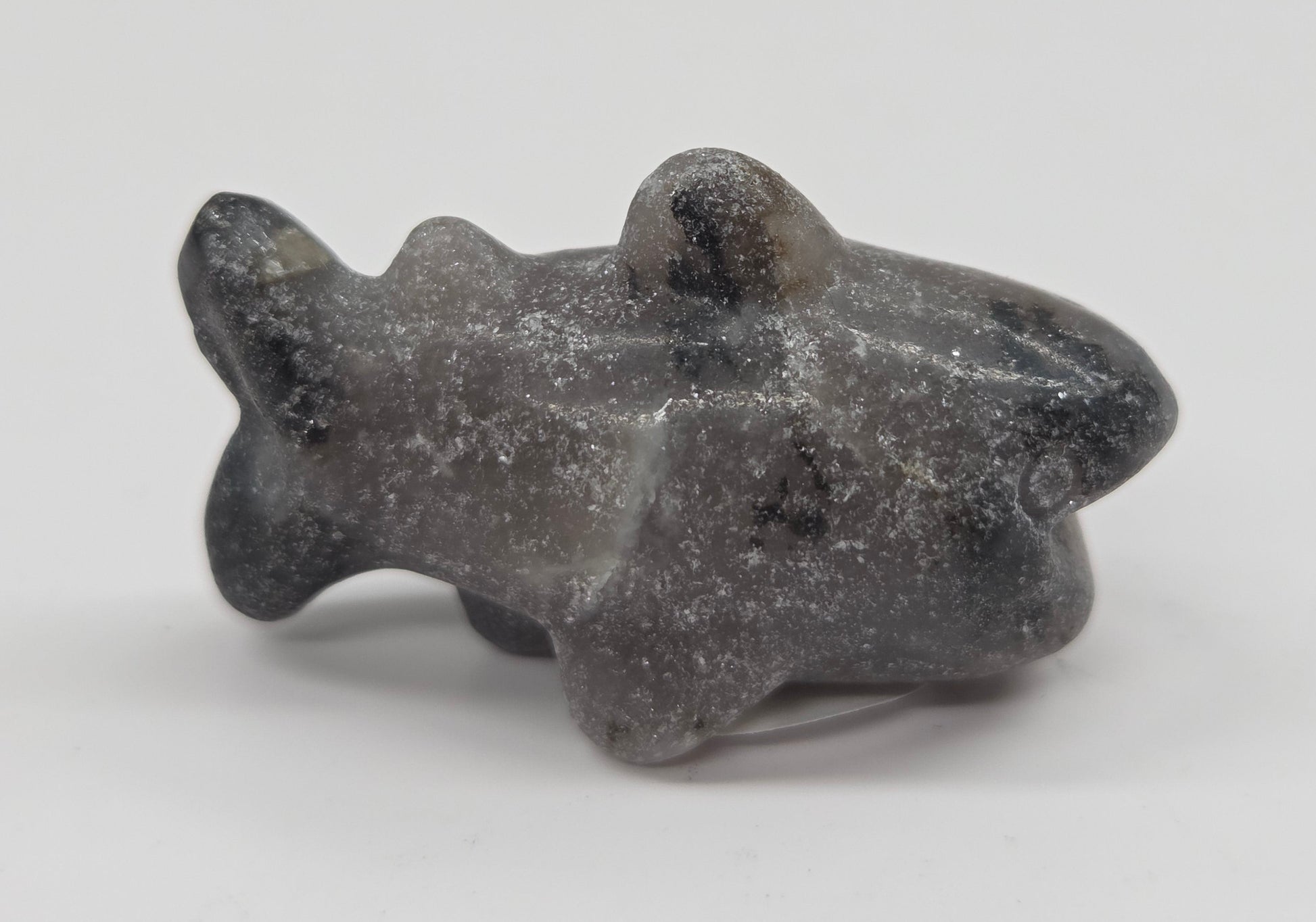 Grey and black colored crystal shark carving on a white background
