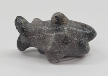 Grey and black colored crystal shark carving on a white background