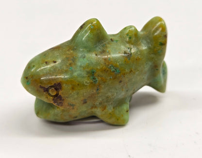 Yellow and greenish colored crystal shark carving on a white background