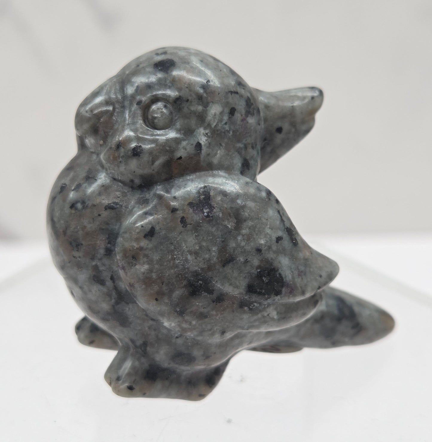 Decorative bird carving made of Yooperlite on a white background