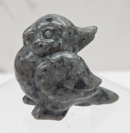 Decorative bird carving made of Yooperlite on a white background