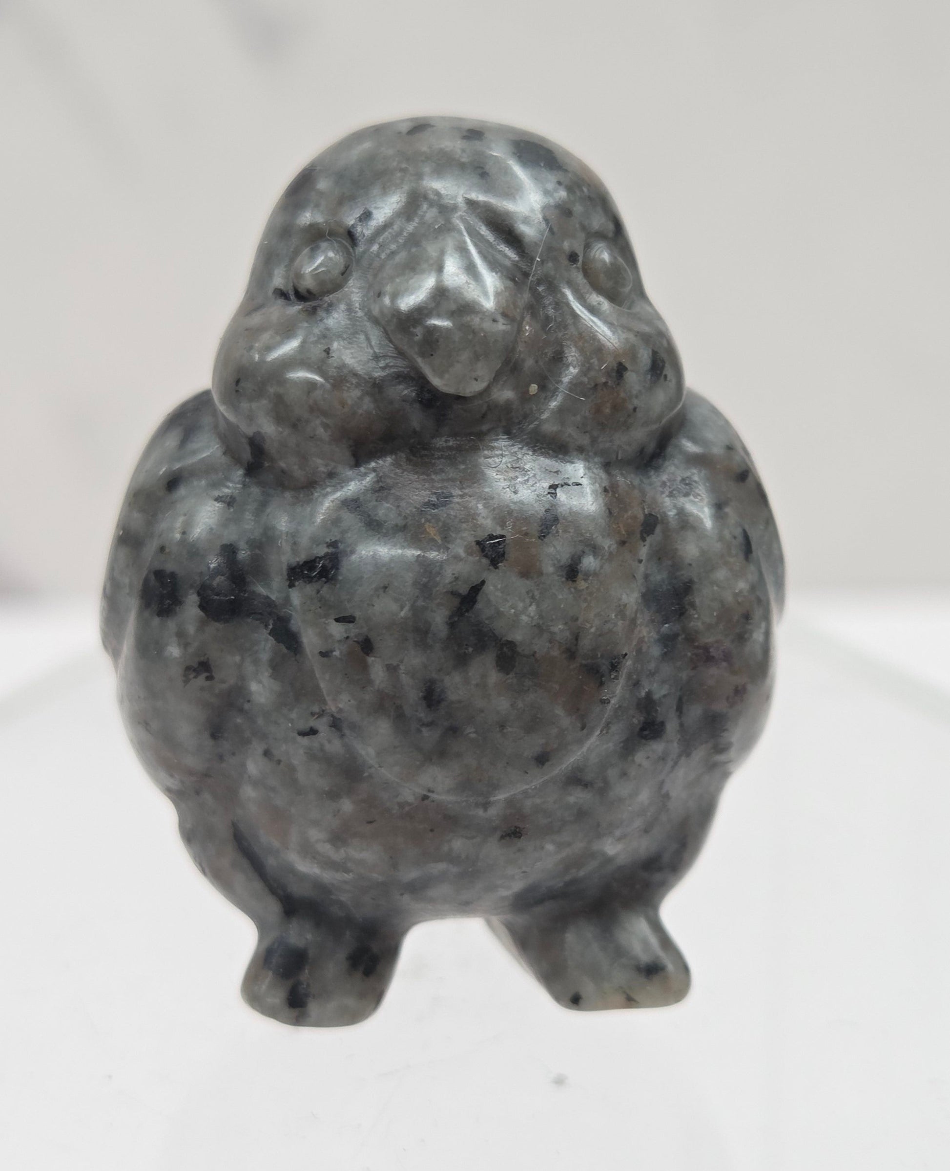 Decorative bird carving made of Yooperlite on a white background