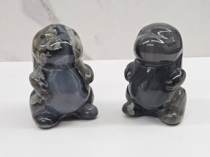 Two Volcano Agate cute dinosaur like carvings on a white background