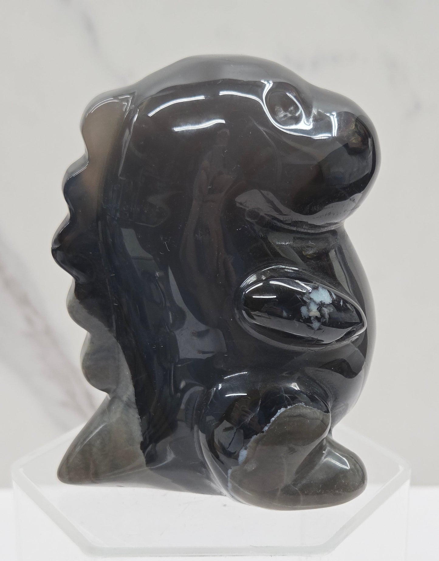 Volcano Agate cute dinosaur like carving on a white background